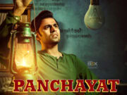 Panchayat Season 4 Release Date & Season 3 Highlights Bright-Faced Man Holding A Vintage Lantern With A Serious Expression, Set Against A Textured Background With Hindi Script, Promotional Poster For The Film &Quot;Panchayat&Quot; Available On Inside Box Office.